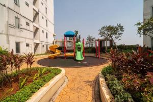 un parque infantil con un tobogán verde en un patio en Comfy & stylish 2 Bedrooms At Bassura city en Yakarta