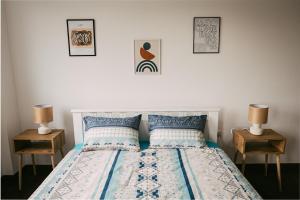 een slaapkamer met een bed met twee nachtkastjes en twee lampen bij Klicakn in Subotica