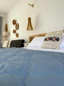 um quarto com uma cama com um cobertor azul em Seaside Studios em Arkasa