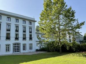 a large white building with a tree in front of it at Balneario de Cestona in Zestoa