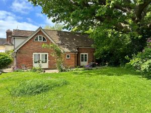 una casa de ladrillo en un patio con césped verde en Peaceful cottage with private garden en Hailsham