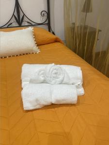 una pila de toallas sentadas encima de una cama en Cut' Home, en Monreale