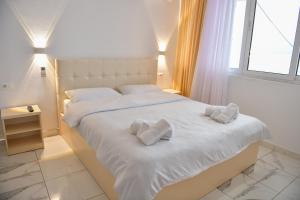 um quarto com uma cama branca com duas almofadas em LakeFront House em Široka