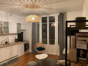 cocina con lámpara de araña, mesa y silla en Le George Sand- hyper centre lumineux, en Tours