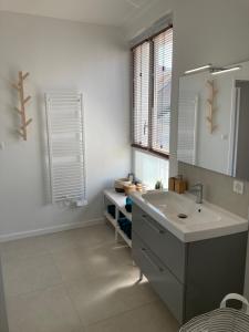Baño blanco con lavabo y espejo en Le George Sand- hyper centre lumineux en Tours