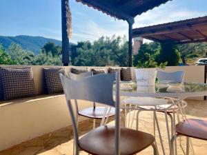 a table and chairs sitting on a patio at Nepis Cottage, GcollectionGr in Ermioni