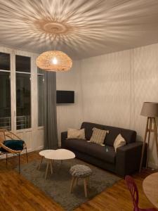 sala de estar con sofá y mesa en Le George Sand- hyper centre lumineux en Tours