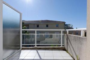 - un balcon avec une porte coulissante en verre et un bâtiment dans l'établissement Studio avec balcon et garage, à Marseille
