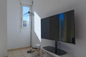 un salon avec une grande télévision murale à écran plat dans l'établissement Studio avec balcon et garage, à Marseille