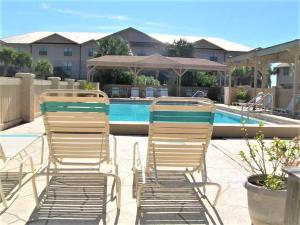 two lawn chairs sitting next to a swimming pool at Beach Rendezvous in Navarre