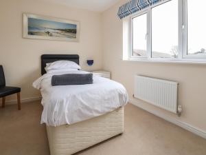 a bedroom with a white bed and two windows at 9 Bluebell Lane in Newport