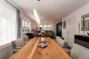 sala de estar con mesa de madera y sillas en Ferienwohnung RottachSuite, en Rottach-Egern