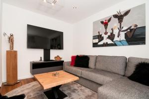 sala de estar con sofá y TV en Ferienwohnung RottachSuite, en Rottach-Egern