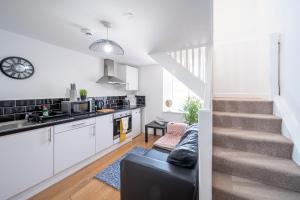 een keuken en een woonkamer met een trap en een bank bij Bv Kirkstall Central 1 Bedroom Apt Free Private Parking in Leeds