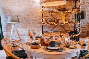 a table with candles and food on it with lights at Manoir le Courtillon in Le Pont Réan