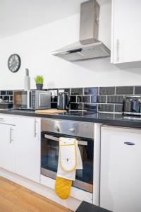 una cocina con fogones y una toalla colgada. en Bv Kirkstall Central 1 Bedroom Apt Free Private Parking, en Leeds