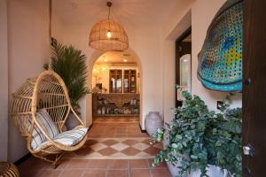 a hallway with a wicker chair and a plant at Boutique Hotel La Ciudadela Marbella in Marbella