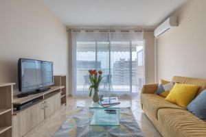 un soggiorno con un divano e una TV di Riviera Home a Beausoleil