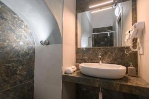 La salle de bains est pourvue d'un lavabo et d'un miroir. dans l'établissement Alessia Holiday House 90mq Salerno Centro, à Salerne