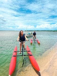 a man and a woman on a bike in the water at Pousada o Forte in Mangue Sêco