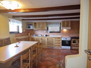 een keuken met houten kasten en een tafel met stoelen bij Apartments Relax Jezerca in Cerklje na Gorenjskem
