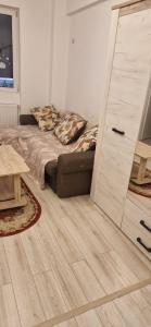 a bedroom with a bed and a wooden floor at Apartament Militari Residence in Roşu +4 photos