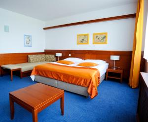 a hotel room with two beds and a table at Garni Hotel Azul in Kranj