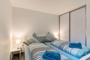 1 dormitorio con 2 camas y almohadas azules en Ferienwohnung Eulennest, en Schramberg