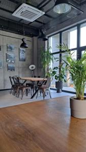 a dining room with a table and chairs and plants at Prowincja Dębki in Dębki