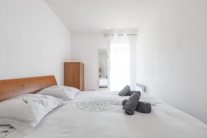 uma cama branca com duas almofadas cinzentas em Riviera Home em Beausoleil