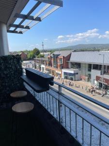 a balcony with two stools and a view of a city at Lux Lisburn Road, Belfast in Belfast