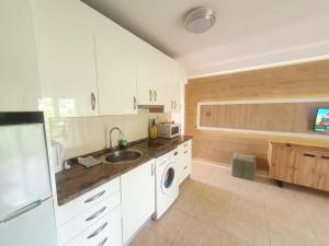a kitchen with white cabinets and a sink and a dishwasher at 5 Salou,Playa,Piscina cento PARKING in Salou