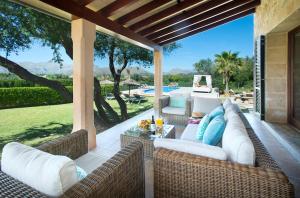 ポリェンサにあるOwl Booking Villa Siquier - Luxury Retreat with Mountain Viewsのプールを望むパティオ(籐の家具付)
