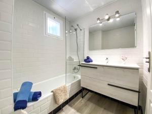 La salle de bains blanche est pourvue d'un lavabo et d'un miroir. dans l'établissement Teach Mhaire apartamento de vacaciones, à Manilva