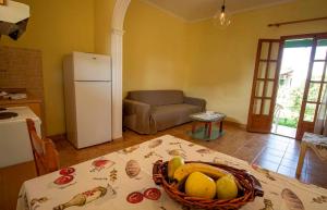 a kitchen with a table with a basket of fruit on it at Tzoras‌ ‌Apartments‌ ‌Roda‌ ‌Corfu‌ in Litherés