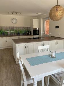 a kitchen with white cabinets and a table with chairs at Landhaus frische Brise 