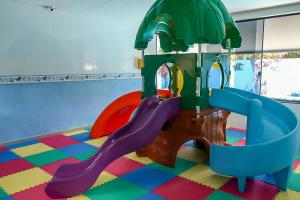 un parque infantil con un tobogán en una habitación en Pousada Ponta de Mangue, en Maragogi