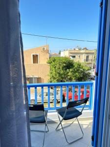 2 sedie su un balcone con ringhiera blu di Leo House Kea a Korissía