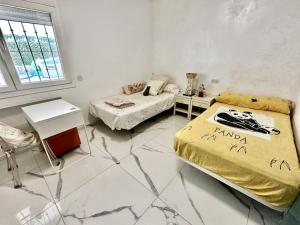 1 dormitorio con 2 camas en una habitación con suelo de mármol en Beachfront apartment with pleasant views of the sea and the historic lighthouse., en Mijas Costa