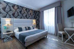 En eller flere senge i et værelse på Hotel Rombino