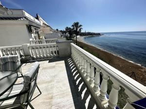un balcón de una casa con vistas al océano en Beachfront apartment with pleasant views of the sea and the historic lighthouse., en Mijas Costa