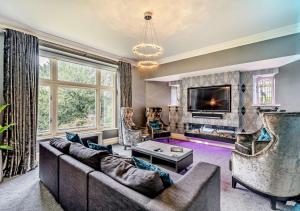 uma sala de estar com um sofá e uma televisão em Maison On Windermere em Bowness-on-Windermere