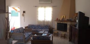 a living room with a couch and a tv at Toulas House in Elíka