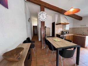 Il comprend une cuisine et une salle à manger avec une table et des chaises en bois. dans l'établissement 6COMA6 Appartement avec terrasse vue mer, à Collioure