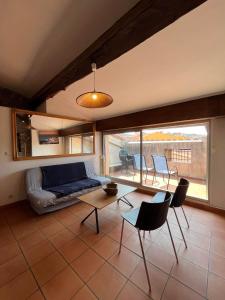 - un salon avec un canapé, une table et des chaises dans l'établissement 6COMA6 Appartement avec terrasse vue mer, à Collioure