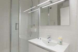 a white bathroom with a sink and a shower at Studio Cosy Aigues Marines in Saint-Cyr-sur-Mer