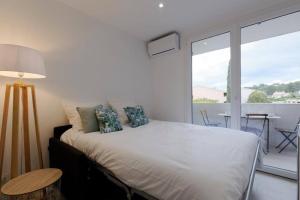 a bedroom with a bed and a balcony with a table at Studio Cosy Aigues Marines in Saint-Cyr-sur-Mer