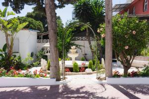 a garden with a fountain and flowers in front of a building at Rancho Grande in Marbella