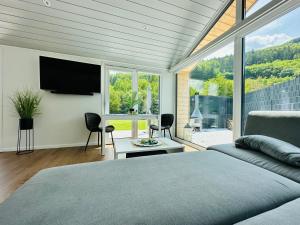 a bedroom with a bed and a flat screen tv at Voralpen Lodge - Ferienhaus mit Gym & Wellnessbereich in Traisen