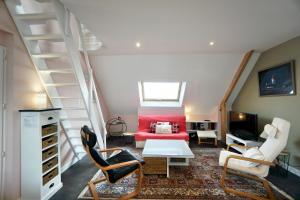sala de estar con cama roja y escalera en Sweet Inn * plage à 200m *, en Ploemeur